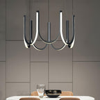 Clérachic looped arm pendant in black over a dining table against a panelled wall.
