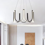 Clérachic looped arm pendant lit in a bright room, its curves set against the window.