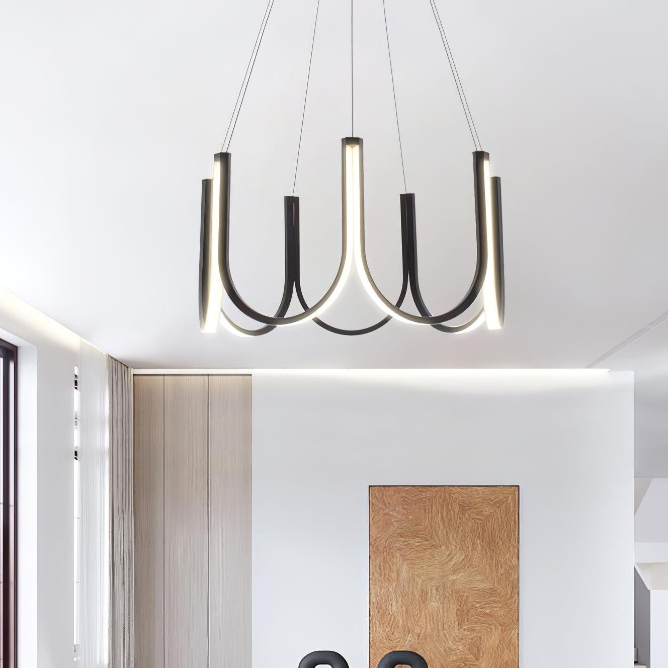 Clérachic looped arm pendant lit in a bright room, its curves set against the window.