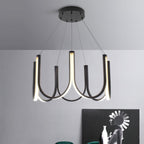 The Clérachic looped arm pendant above a sideboard, black arms framing the artwork behind.