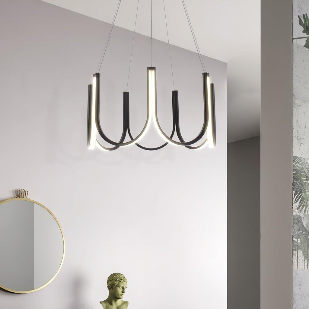 The Clérachic looped arm pendant on a white wall beside a round mirror and plaster bust.