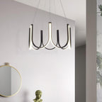 The Clérachic looped arm pendant on a white wall beside a round mirror and plaster bust.