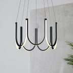 Clérachic looped arm pendant against a raw concrete wall beside a potted palm.