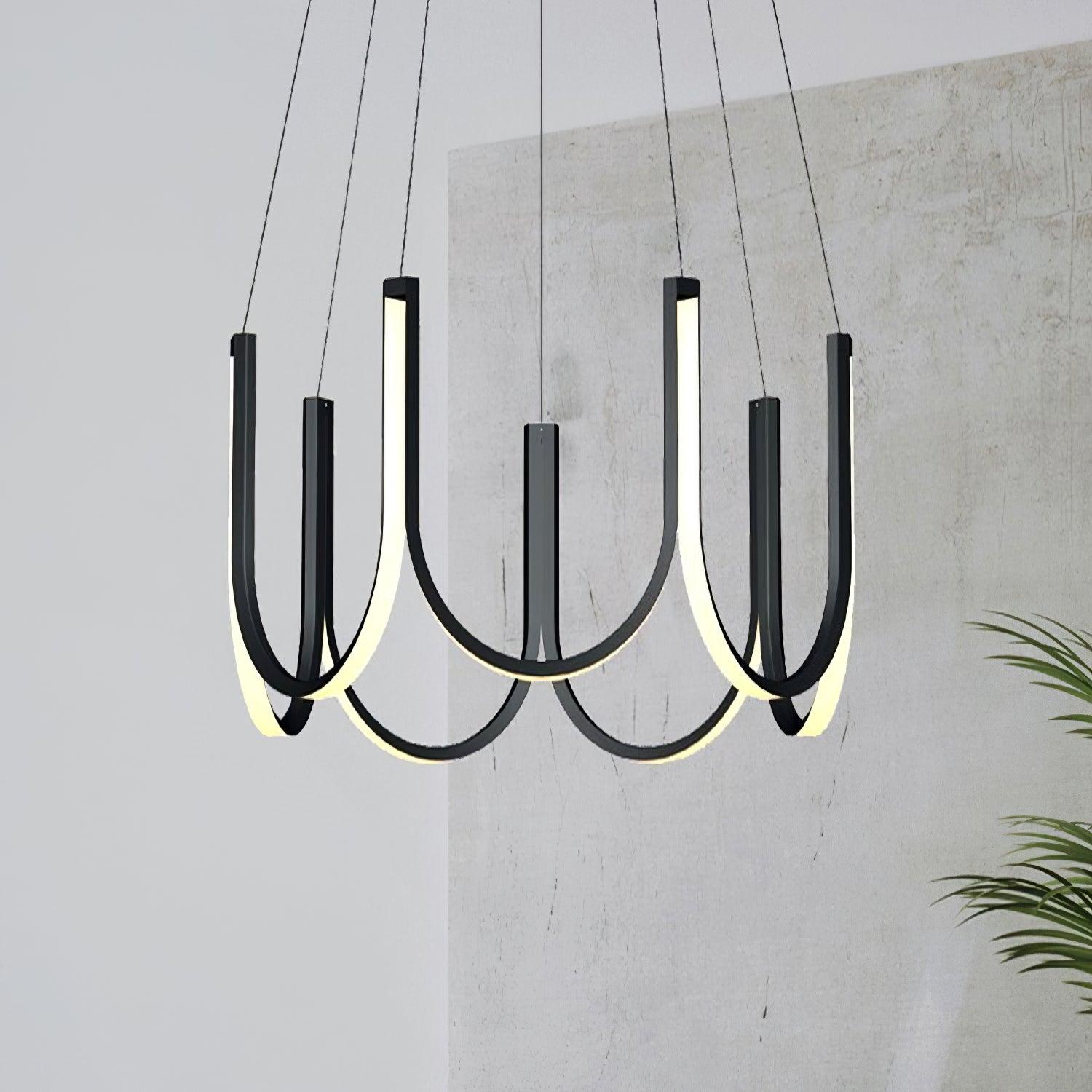 Clérachic looped arm pendant against a raw concrete wall beside a potted palm.