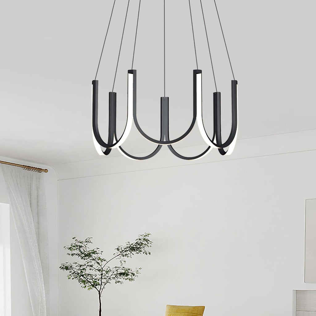 Clérachic looped arm pendant in a white room beside a slender indoor tree.