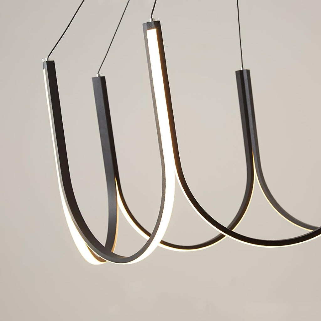 Close view of three Clérachic pendant loops, warm light running along the inner face.