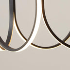 Macro of two Clérachic pendant arms crossing, the lit strip curving through the frame.