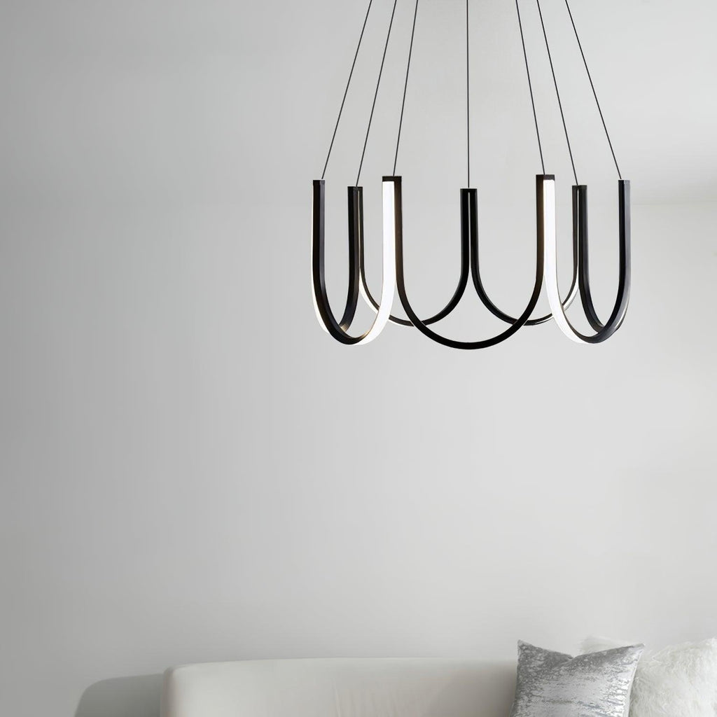 The Clérachic looped arm pendant above a pale sofa against a plain white wall.