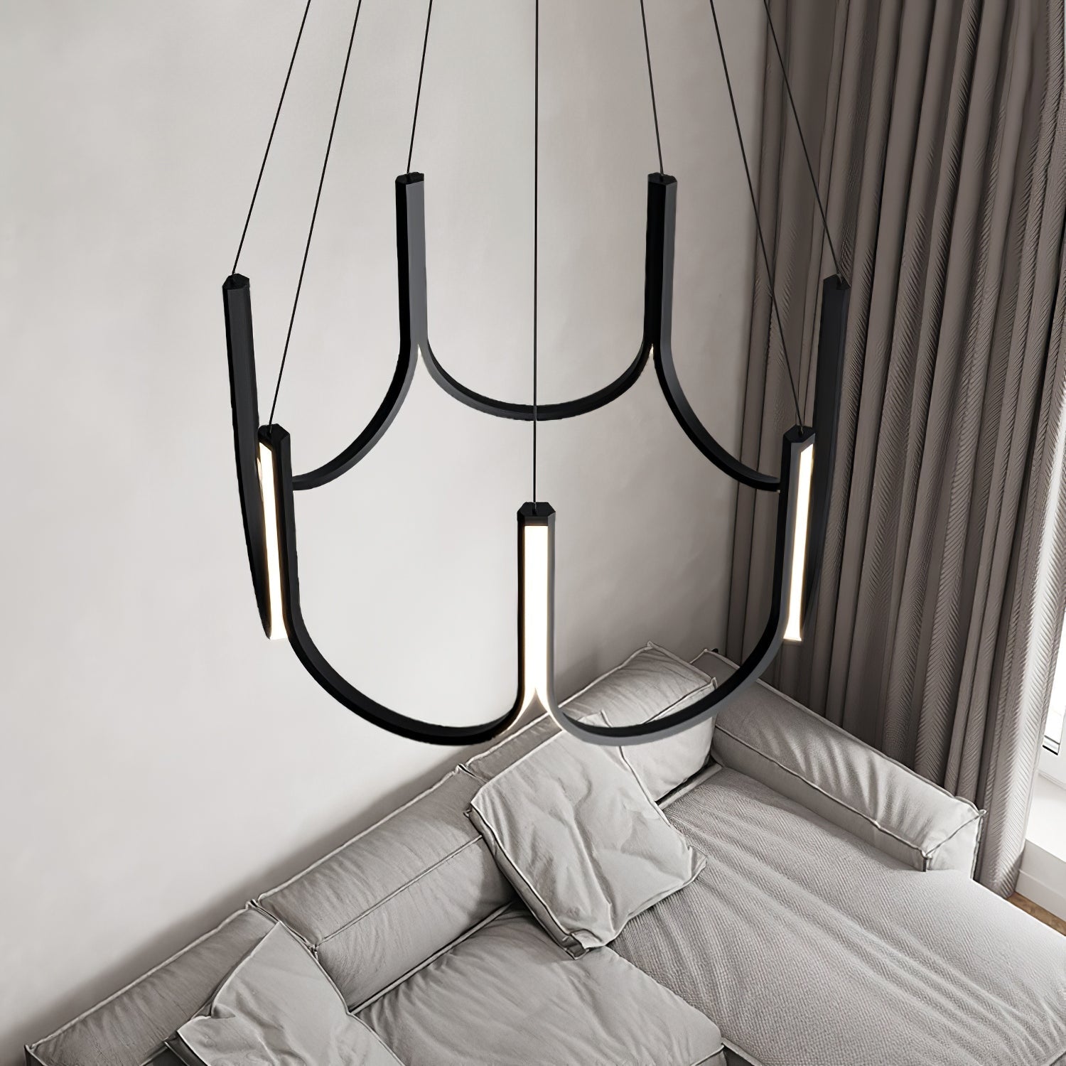 The Clérachic looped arm pendant above a grey sofa and heavy floor-length curtains.