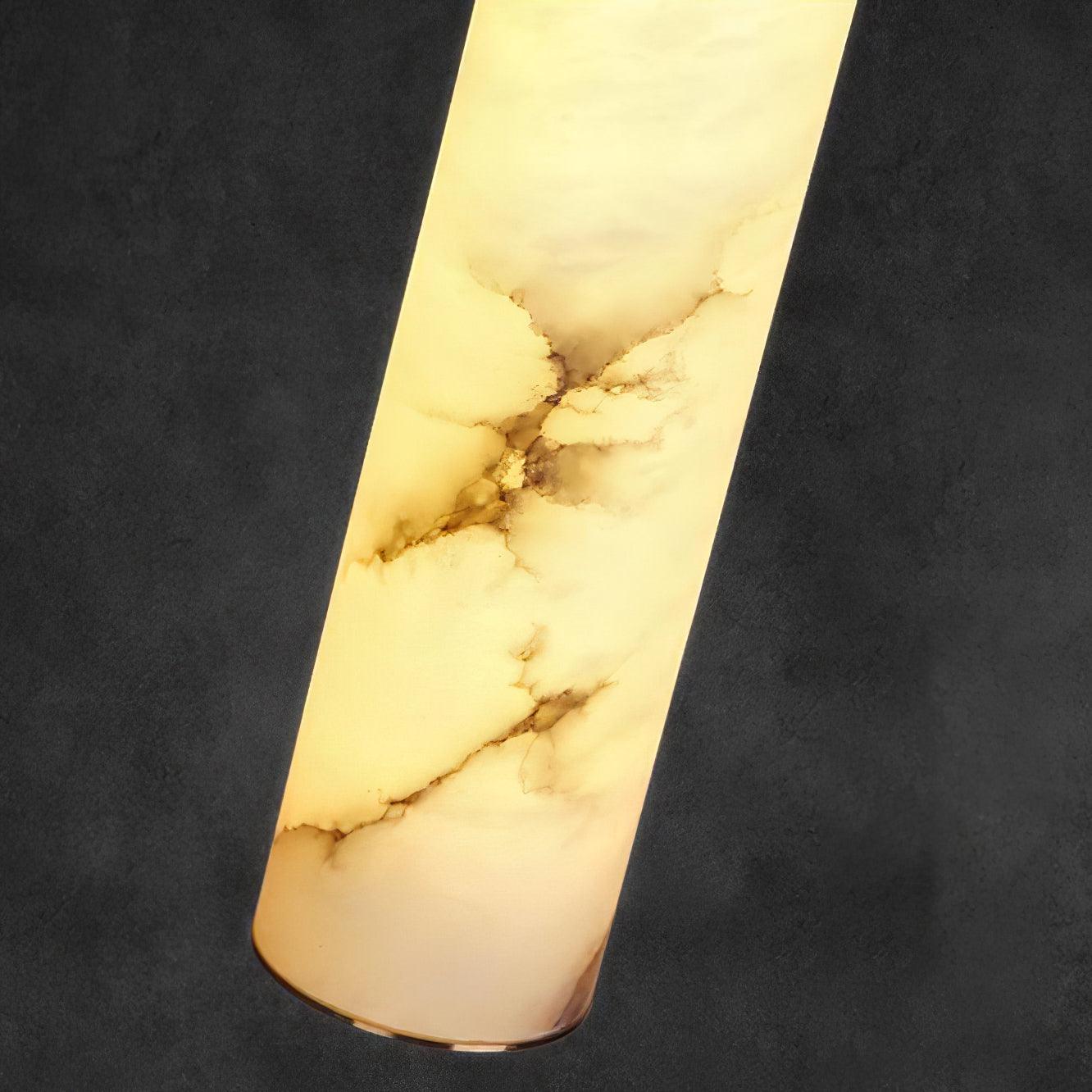 The Clérachic alabaster shade backlit in macro, amber and smoke veining reading clearly through the polished stone.