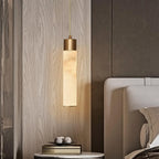 Clérachic mounts a single drop beside an oak-panelled bedroom wall, pooling warm light over a round bedside table.