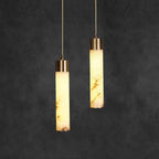 Clérachic cylinders lit against a deep grey backdrop, showing how tone differs from one alabaster shade to the next.