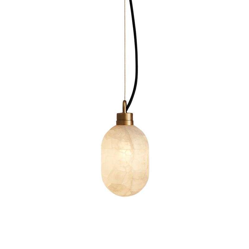 Clérachic Eclipse pendant lit against white, its alabaster shade glowing warm beneath a slim brushed brass collar.