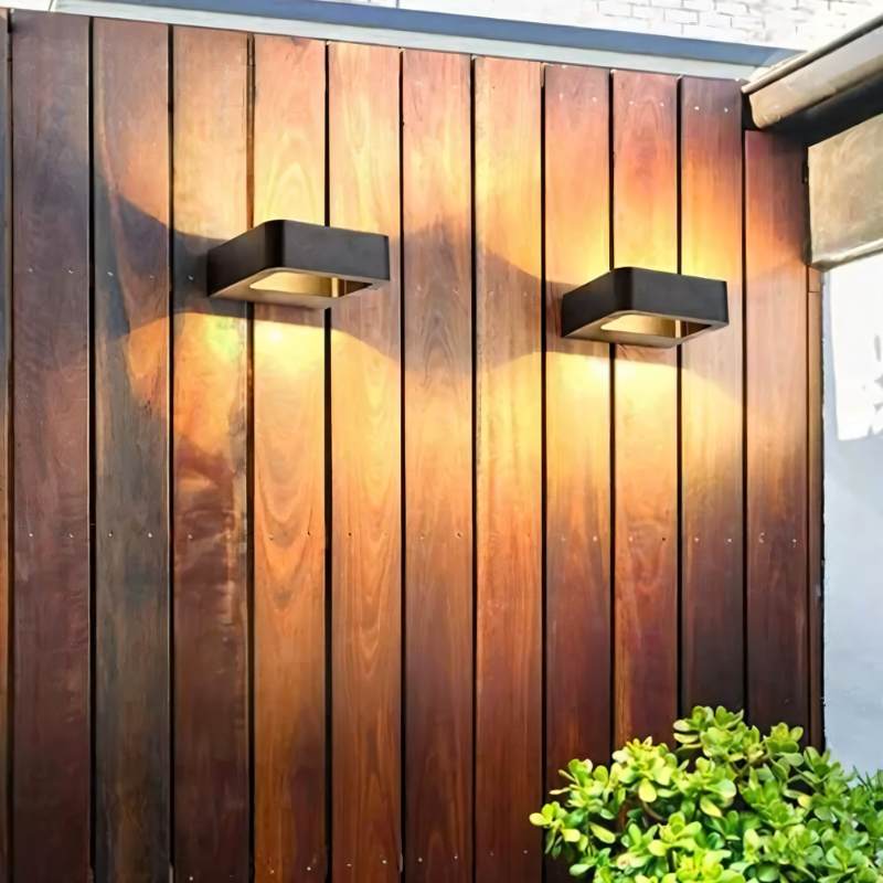 Pair of Clérachic black wall lights on a vertical timber fence, each washing the grain with warm light above and below.