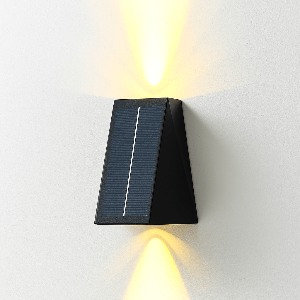 Clérachic black solar wall light with a tilted charging panel, casting warm light upward and downward on a white wall.