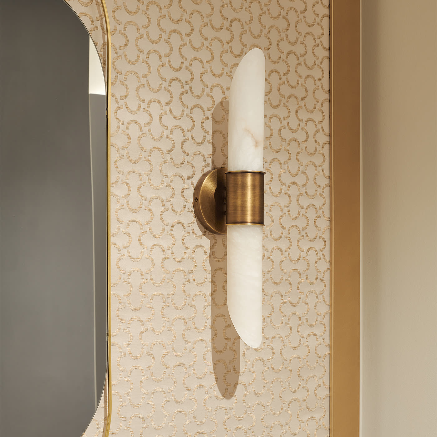 The Clérachic Up-Down Wall Sconce mounted on patterned cream wallpaper beside a gold-framed mirror in a powder room.