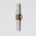 Angled view of the Clérachic Up-Down Wall Sconce on a pale grey wall, showing the aged brass collar and round backplate.