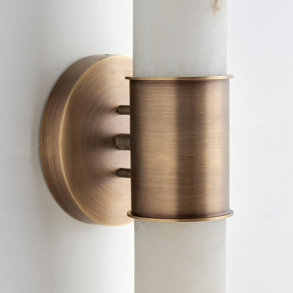 Close-up of the Clérachic Up-Down Wall Sconce's brass collar and backplate, showing the three threaded mounting studs.