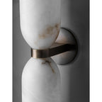 Clérachic alabaster sconce in detail, caramel veining drifting through the upper cup where the brass band grips the narrow waist.