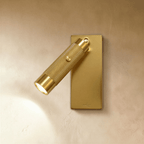 Clérachic wall reading light in bright gold, a knurled cylinder spot with a push switch on a slim rectangular backplate.
