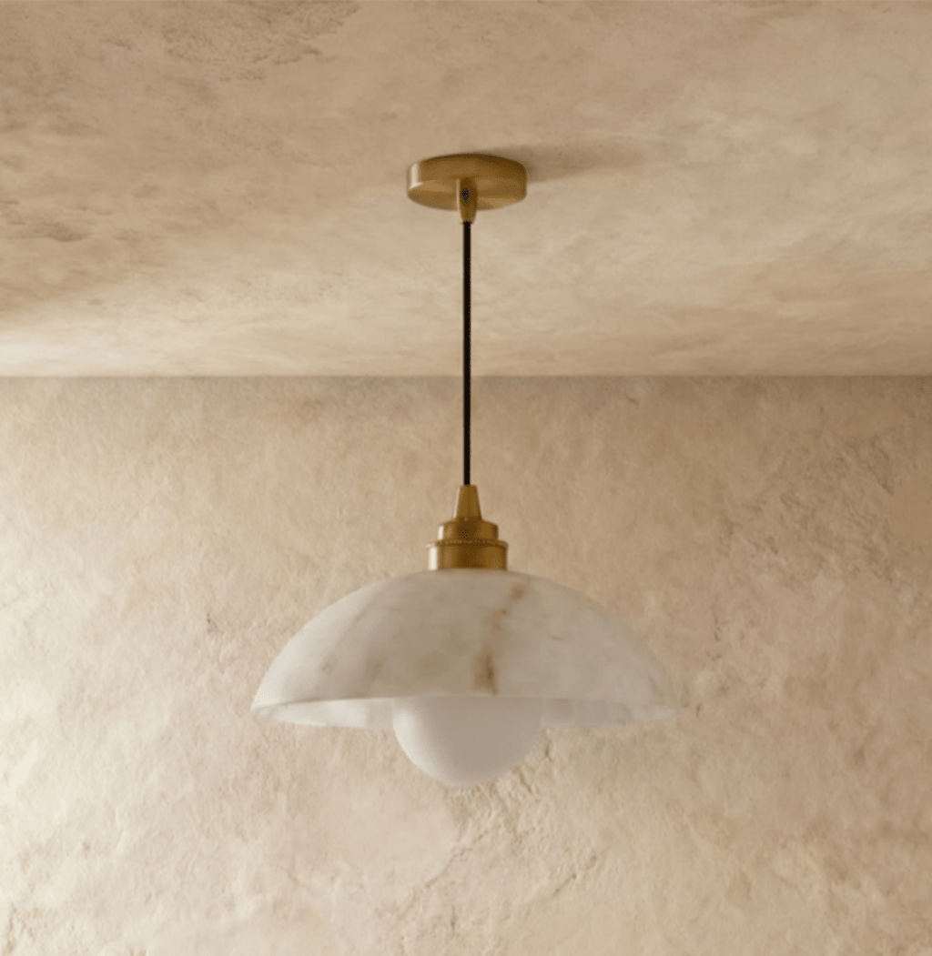 Clérachic veined alabaster dome pendant hung from a gold canopy and black cord, with a frosted globe bulb below.