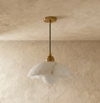 Clérachic veined alabaster dome pendant hung from a gold canopy and black cord, with a frosted globe bulb below.