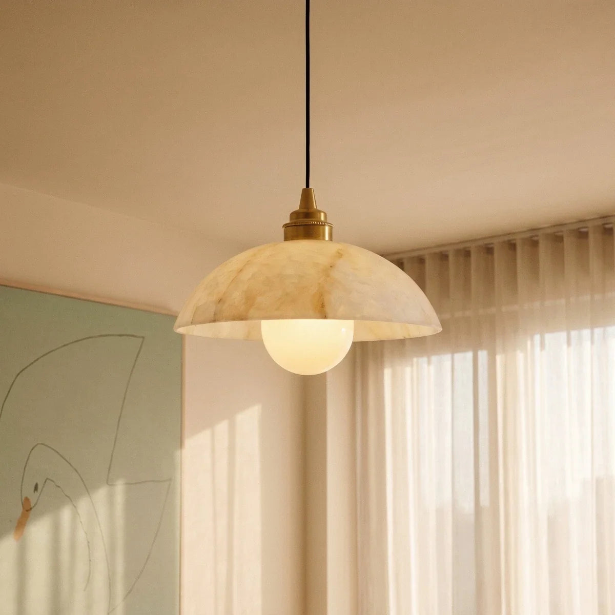Clérachic alabaster dome pendant in warm afternoon light, gold top fitting, globe bulb, sheer curtains and a pale painting.