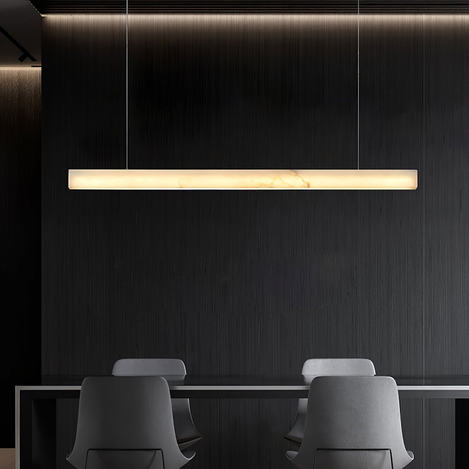 The Clérachic Velmore bar pendant over a dark island with two low chairs pulled up to it.