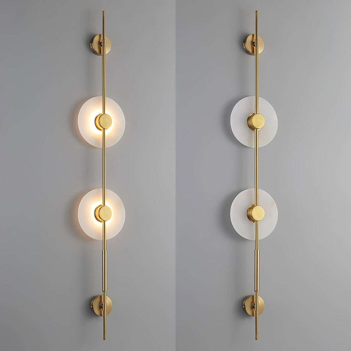 Two gold Clérachic sconces side by side, one with its discs lit and one unlit, against a grey wall.
