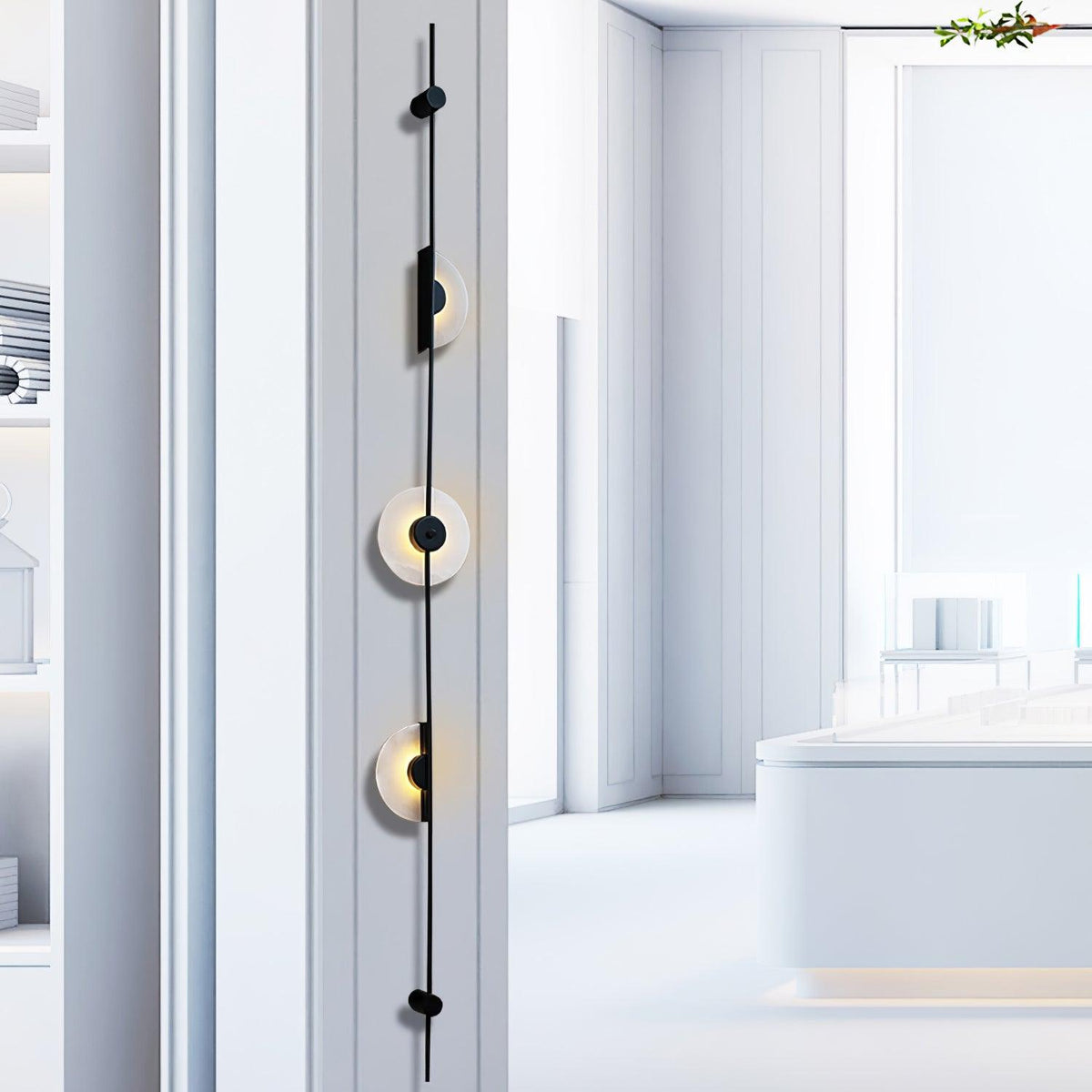 Close, angled view of a black three-disc Clérachic sconce on a white wall, with a pale display space behind.