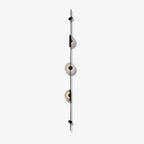 Black three-disc Clérachic sconce unlit on a pale background, its alabaster discs and slim rod seen side-on.