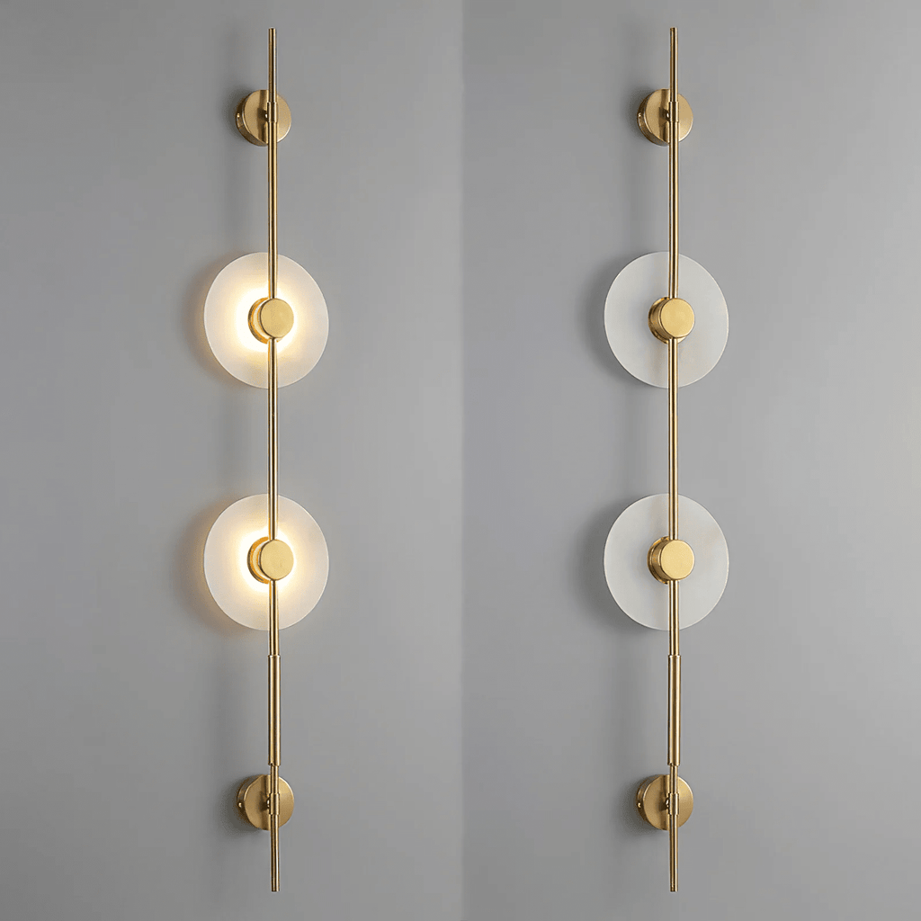 Two gold Clérachic sconces on a grey wall, a two-disc model lit on the left and the same unlit on the right.