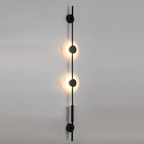 Black Clérachic sconce with two warmly lit alabaster discs on a grey wall, seen at a slight angle from below.