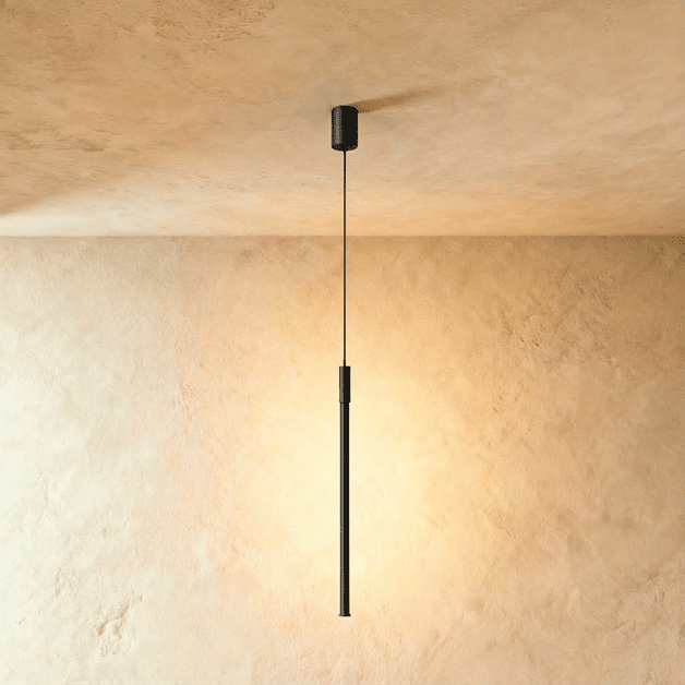 This angle of the Clérachic black rod pendant highlights its brushed cylinder joint above the glowing tip.
