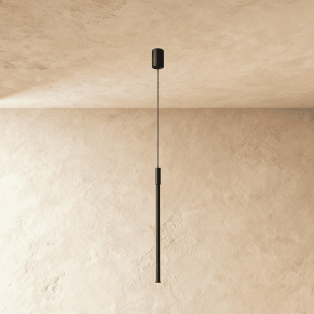 A longer Clérachic black vertical pendant hangs against a plastered corner, its slim rod ending in soft light.