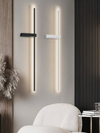 Clérachic black and white LED light bars side by side on a grey wall above a cream armchair and a marble side table.