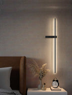 Clérachic black LED light bar on a woven wall beside a brown headboard, above a bedside table with dried grasses and a clock.