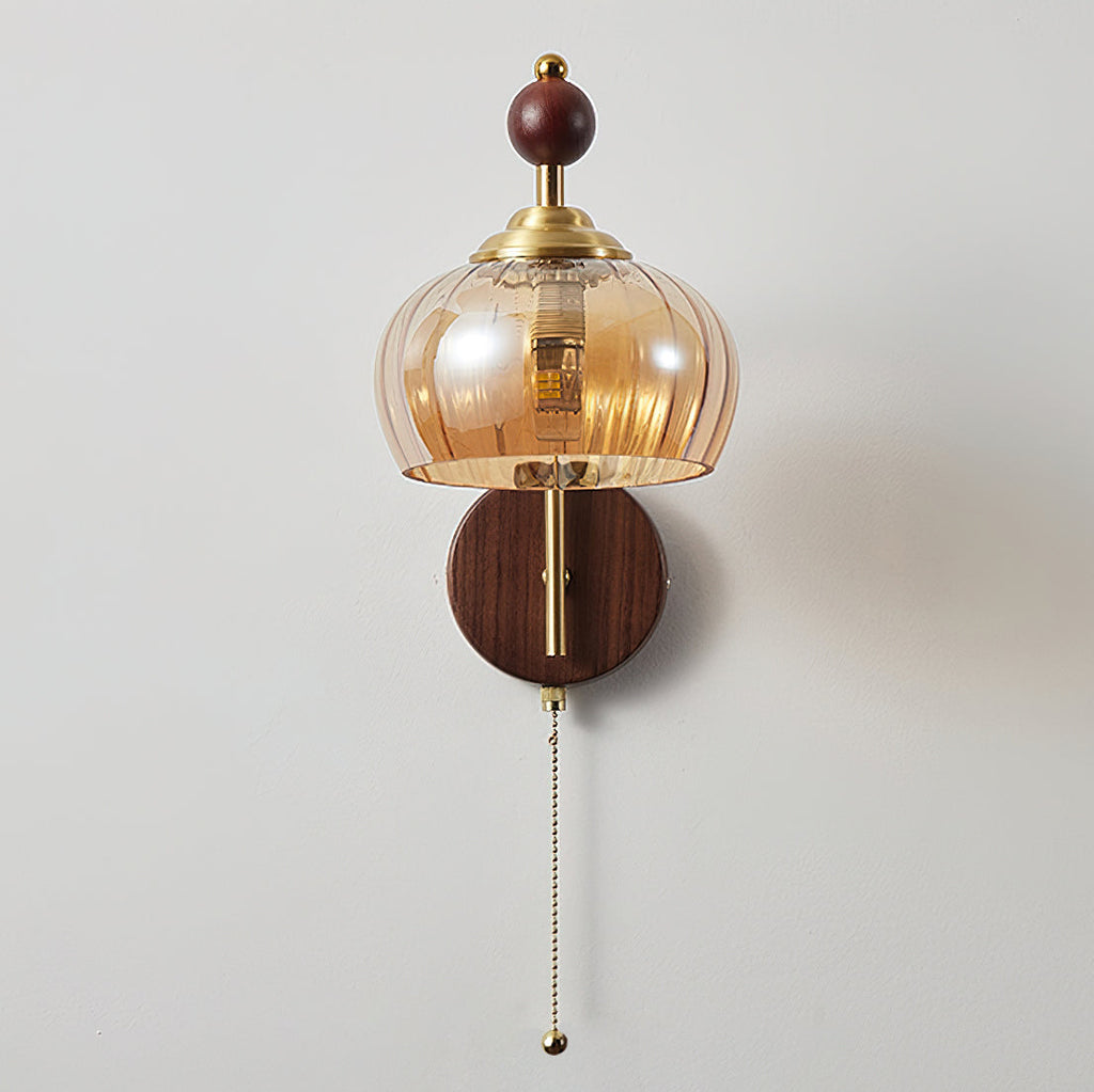 Clérachic wall light with a rounded ribbed amber glass shade and pull chain, unlit, on a plain light wall.
