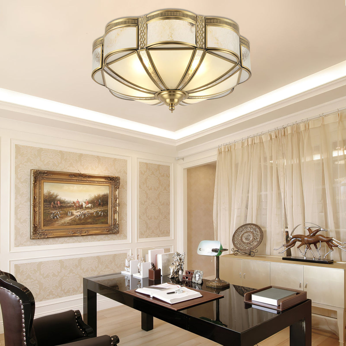 Above a dark glass desk in a panelled study with a gilt-framed painting, this Clérachic brass ceiling light glows under a lit cove.