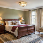 This Clérachic brass ceiling light sits flush above a mahogany sleigh bed in a sage-green bedroom with a patterned rug.