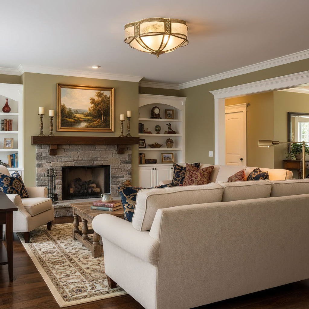 In a living room with a stone fireplace and a cream sofa, this Clérachic flush brass ceiling light gives off a soft warm glow.