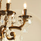 Close view of the cast bronze arms, candle cups and clear glass drops on this Clérachic chandelier.