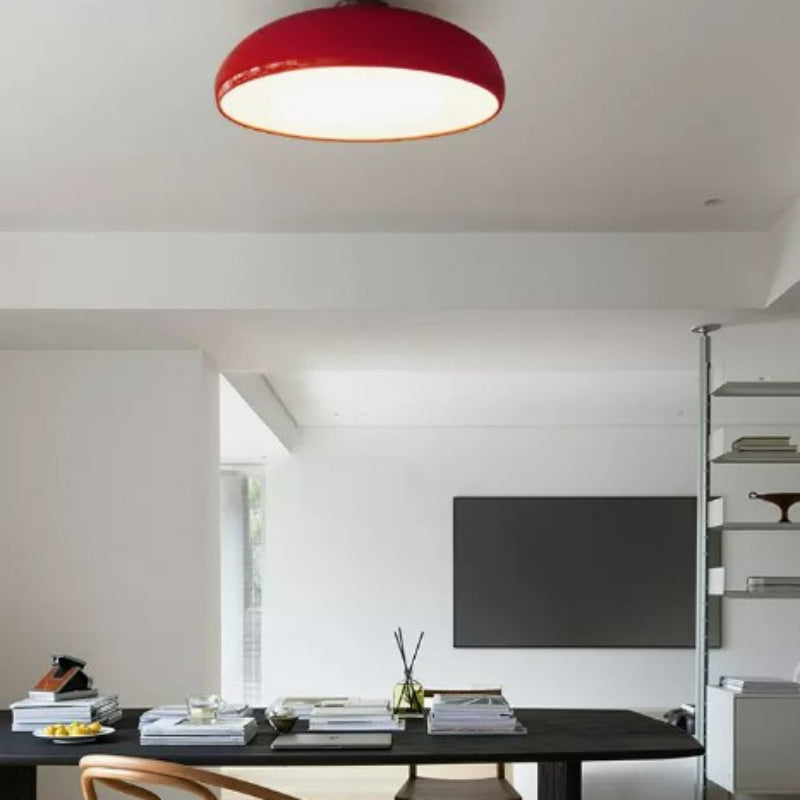 Red Clérachic vintage dome ceiling light glowing above a dining table styled with open shelving.
