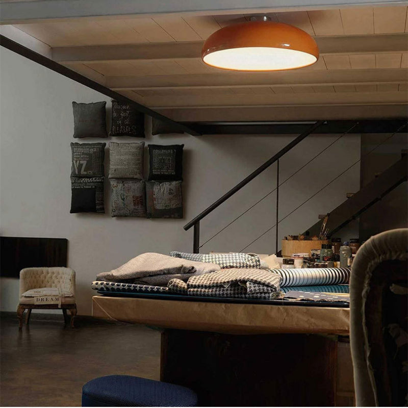 Orange Clérachic vintage dome ceiling light glowing warmly above a cozy loft sewing nook.