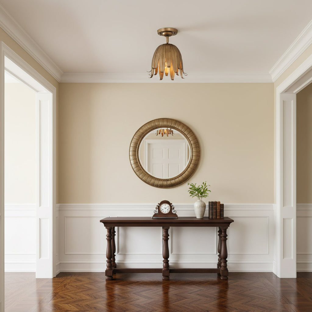 A vintage gold Clérachic petal ceiling light hanging in a hallway, above a dark console table and a round gilt mirror.