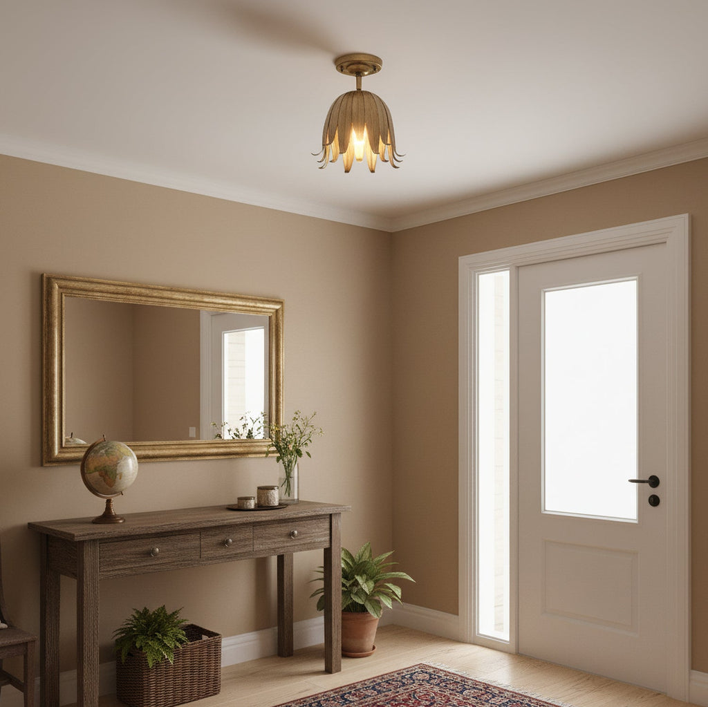This Clérachic ceiling light glowing gold in an entryway, with a wall mirror, a globe and a console table beneath it.
