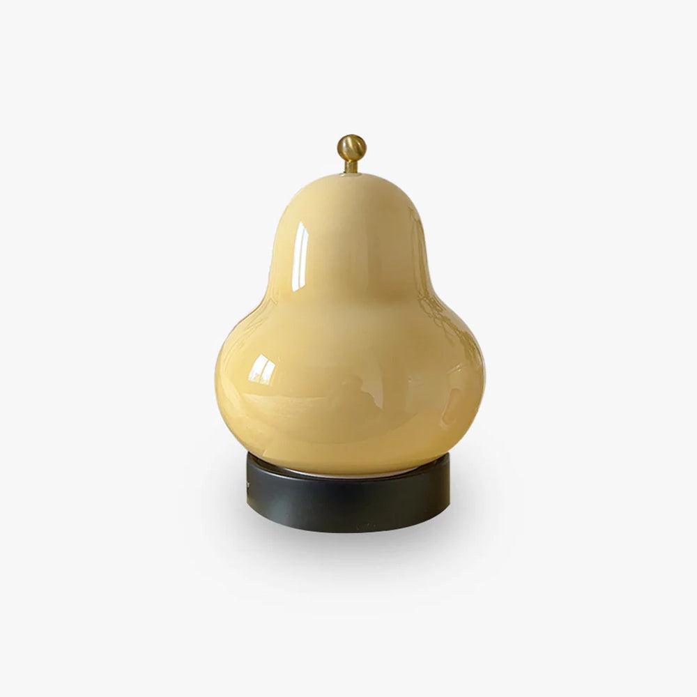 A Clérachic table lamp with a cream glass pear-shaped shade, a small brass knob on top and a round black base, on a plain white backdrop.