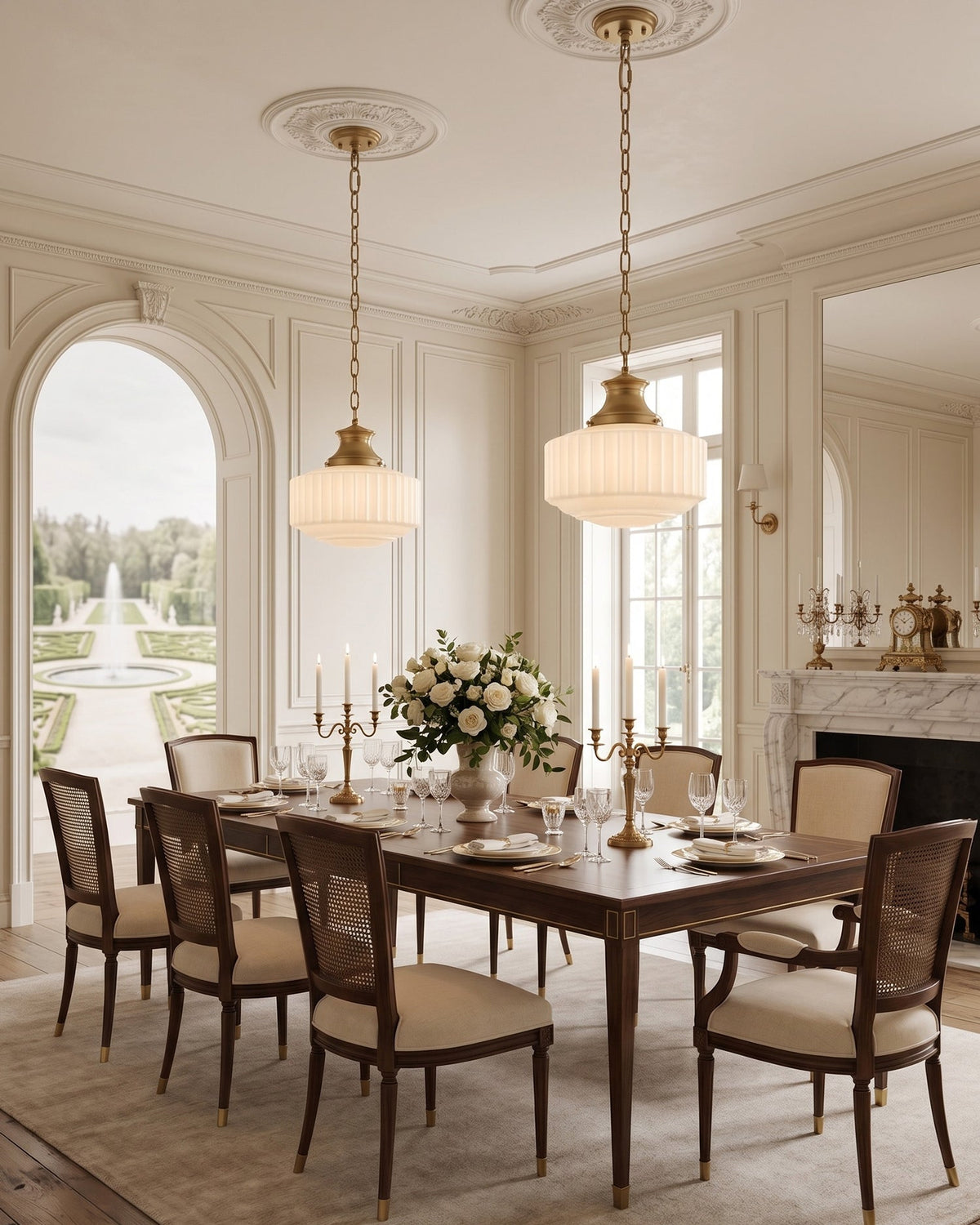 Two Clérachic pendants lit above a long wooden dining table, with an arched window and garden view in a classically panelled room.