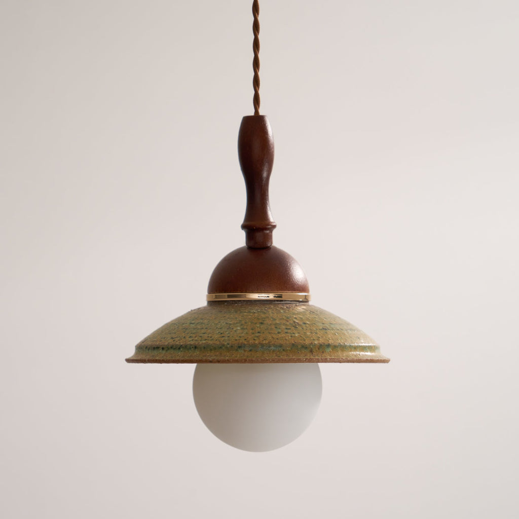 Slightly low angle on this Clérachic pendant, showing the underside of the green shade and the white globe beneath it.