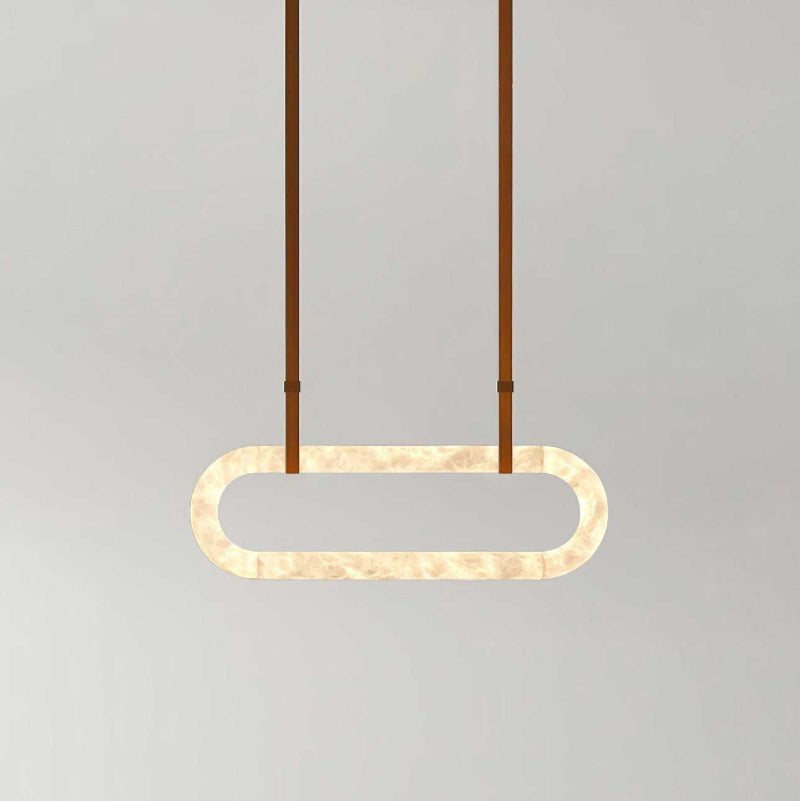 Clérachic Vista suspended on tan straps, the lit alabaster oval casting a warm wash onto the grey backdrop.